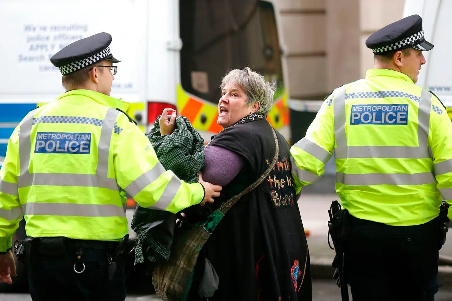 En klimaaktivist fra Extinction Rebellion bliver fjernet af politiet, efter at hun havde lænket sig selv til det britiske trafikministeriums bygning i London.