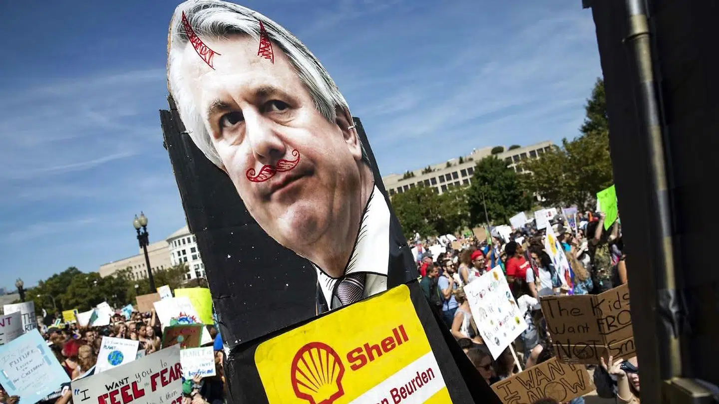 Unge demonstranter bærer et skilt med et billede af Shells topchef, Ben van Beurden. Nu tager han til genmæle mod kritikken af olieselskaberne. Foto: Samuel Corum/AFP/Ritzau Scanpix
