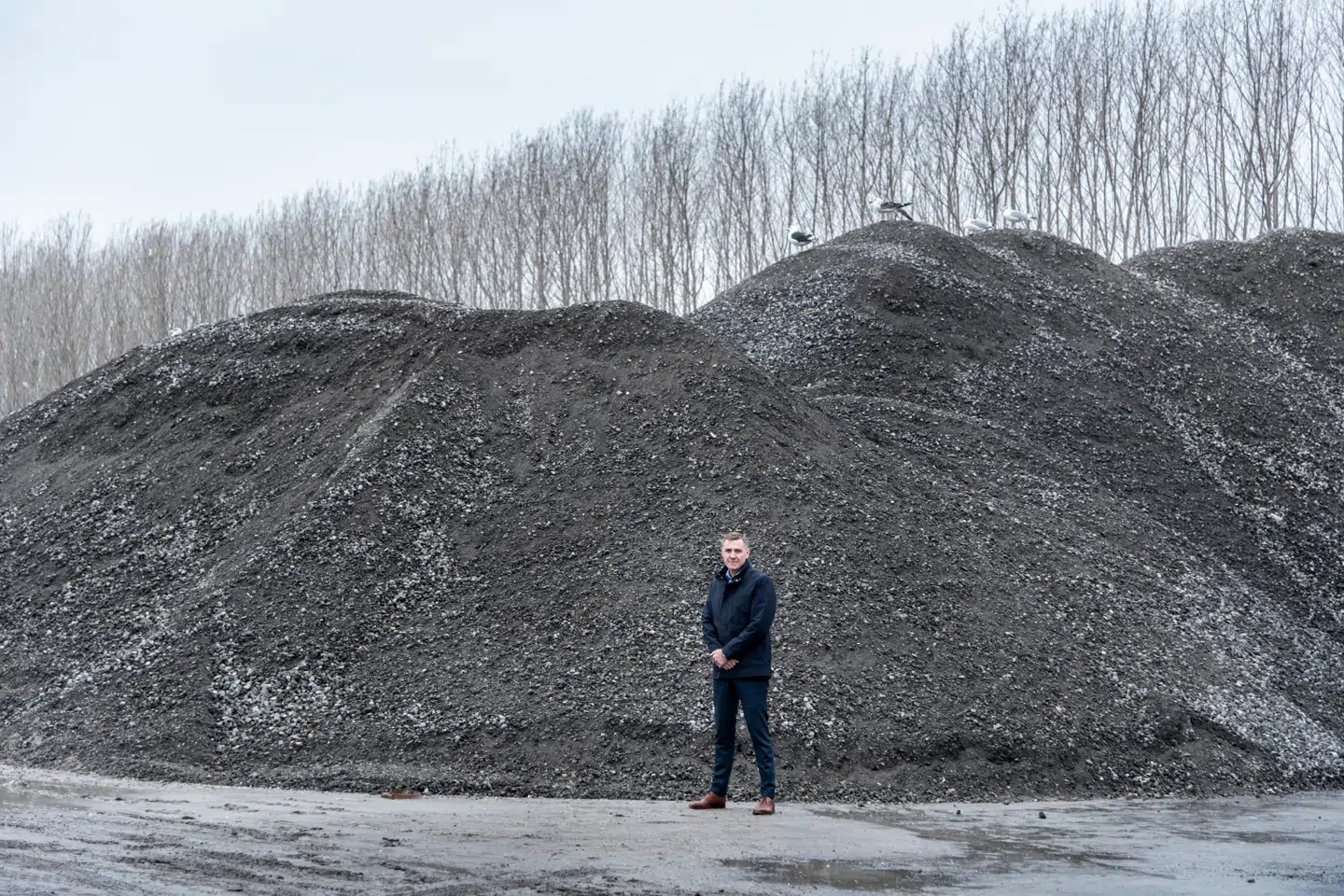 Genbrug af byggematerialer i stor skala handler ikke om at bevare smukke detaljer fra f.eks. døre eller vinduer, men om at genanvende de rå mængder af f.eks. beton og tegl, der ligger tilbage, når en ejendom er revet ned. Det arbejder virksomheden RGS Nordic, der ligger på Selinevej ved Sjællandsbroen, med. På billedet står adm. direktør Henrik Grand Petersen foran en bunke af de enorme mængder af byggeaffald fra nedrevne, københavnske ejendomme. Foto: Cilina Dahl, Scanpix