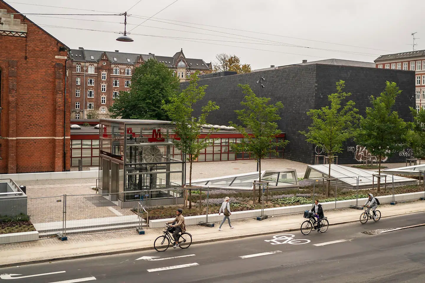 På Nuuks Plads er der lave siddeplinte, og trods standarddesignet formår Metroselskabet at lave en fin lille plads, der samler Dahlerups gamle landsarkiv og Koppels fantastiske skifersarkofag.