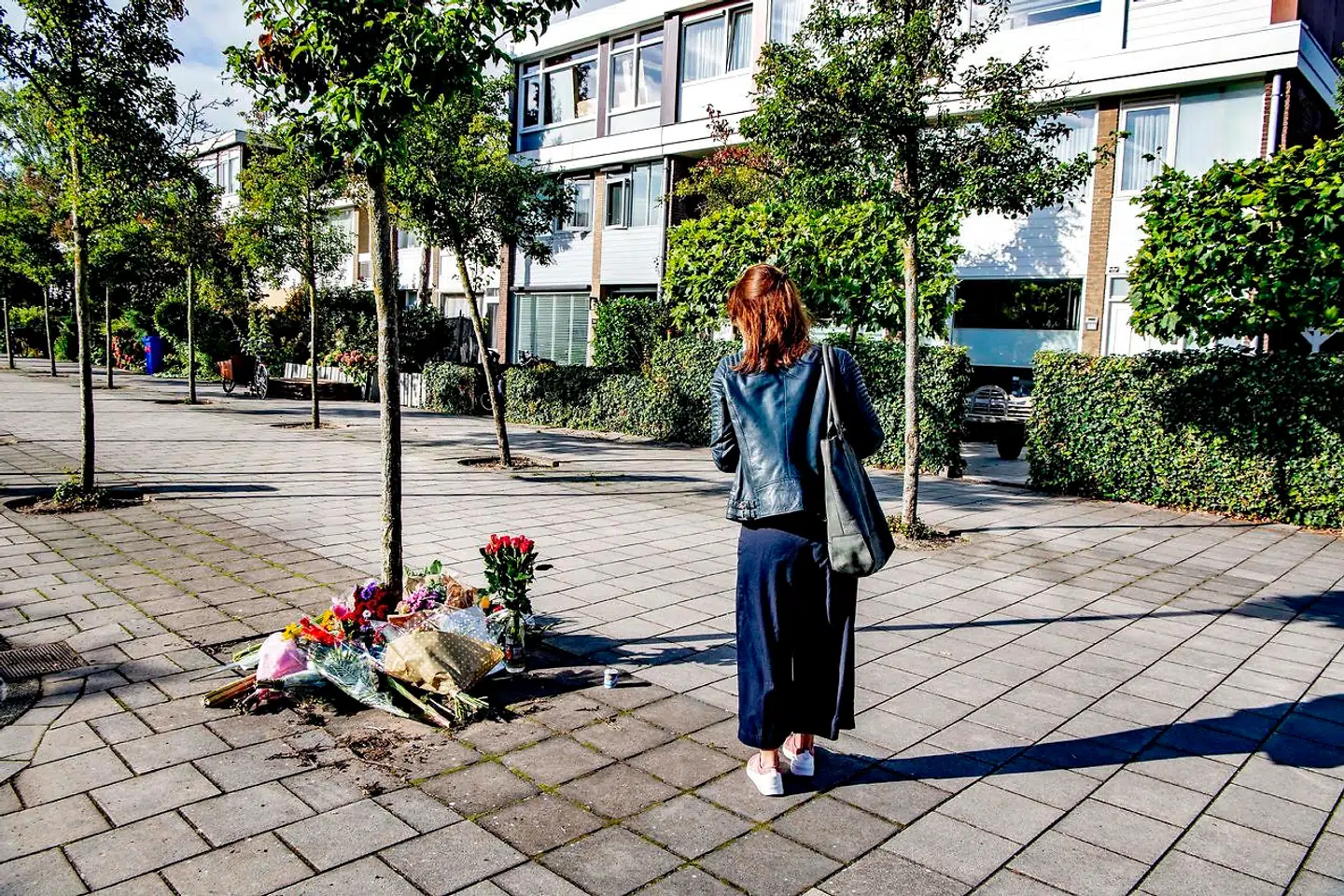 En kvinde gør holdt ved de blomster, der er blevet lagt uden for Derk Wiersums hjem, hvor han onsdag blev skudt. Den 44-årige forsvarsadvokat repræsenterede et kronvidne i en mordsag mod 16 mænd i det hollandske narkomiljø.