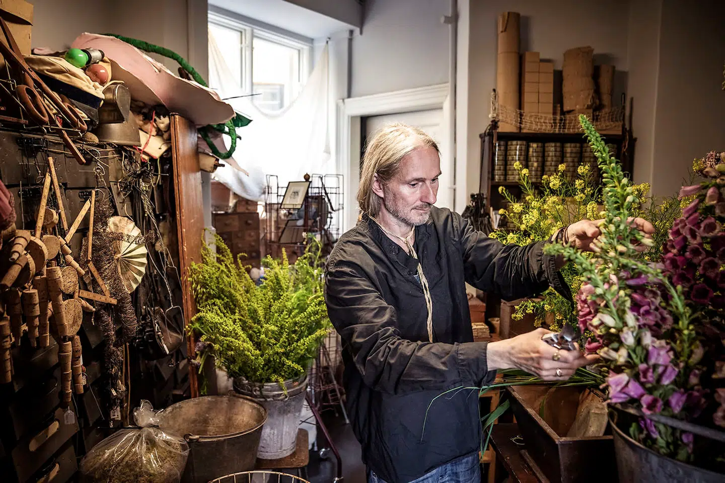 Leif Sigersen i sit værksted – omgivet af blomster og skæve ting, som han elsker.