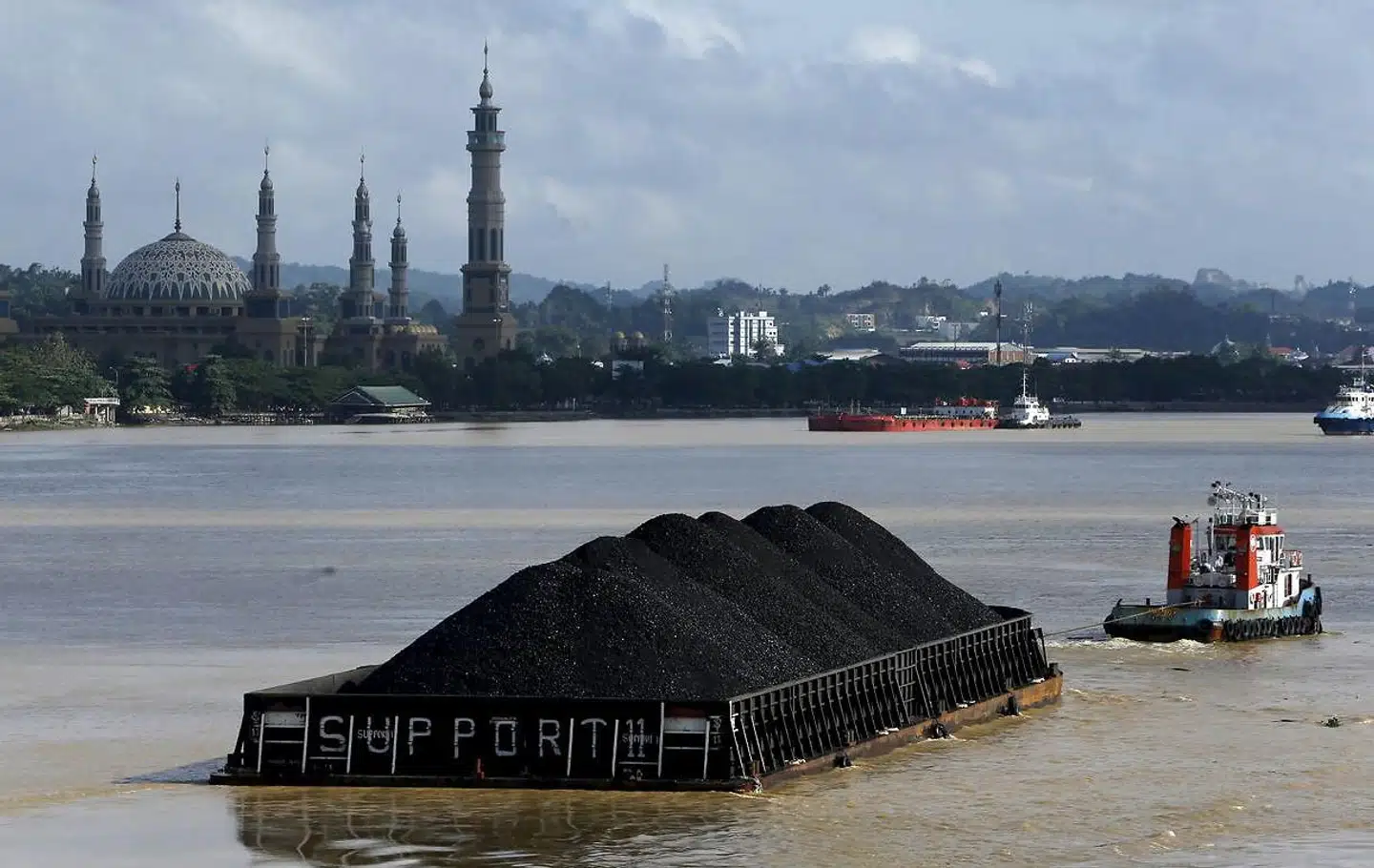 En flodpram med kul på vej til et af Indonesiens stigende antal kulkraftværker. FN advarer nu om, at de fortsatte investeringer i nye kulkraftværker i Asien risikerer at bringe Parisaftalens temperaturmål i fare.