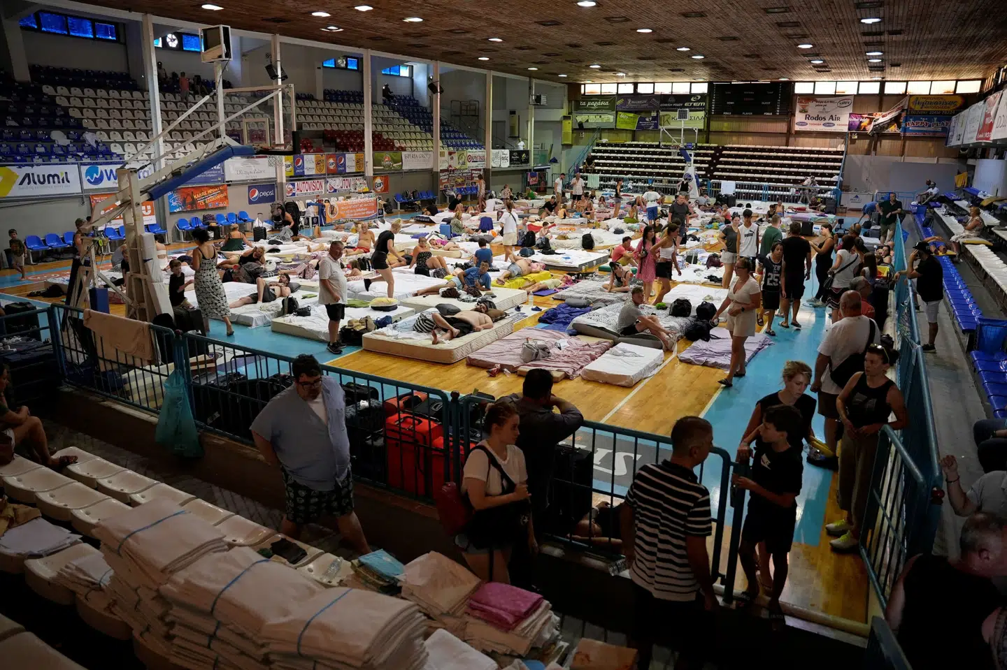 Evakuerede turister ses her i en sportshal søndag. Fedja Grulovic/Reuters