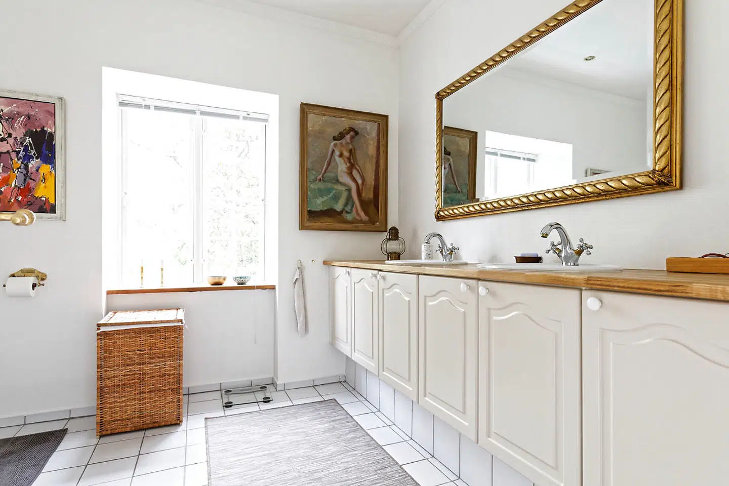 Et tidligere kammer på første sal blev for nogle år siden bygget om til badeværelse. Også her har det kunstglade par hængt malerier op.