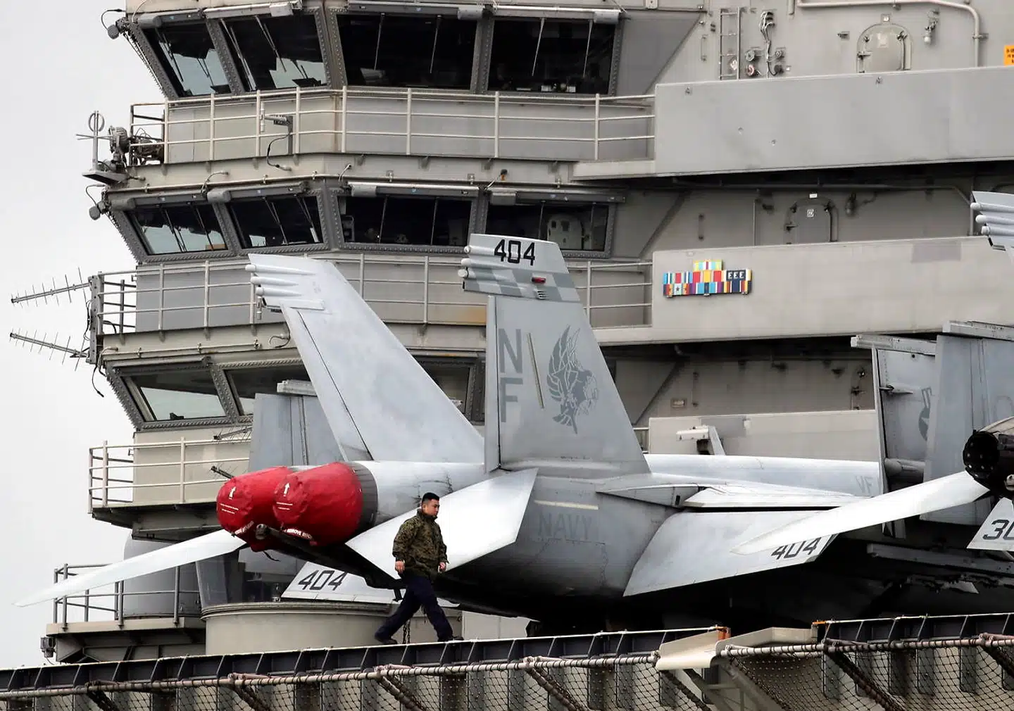 Et amerikansk besætningsmeldem går forbi en F-18 Hornet kampfly på det amerikanske krigsskib USS Ronald Reagan i Det Sydkinesiske Hav. I årevis har amerikanerne været den dominerende militære magt i Stillehavsregionen - men nu tyder meget på, at Kina er USA klar overlegen i regionen. Det viser et nyt australsk studie.