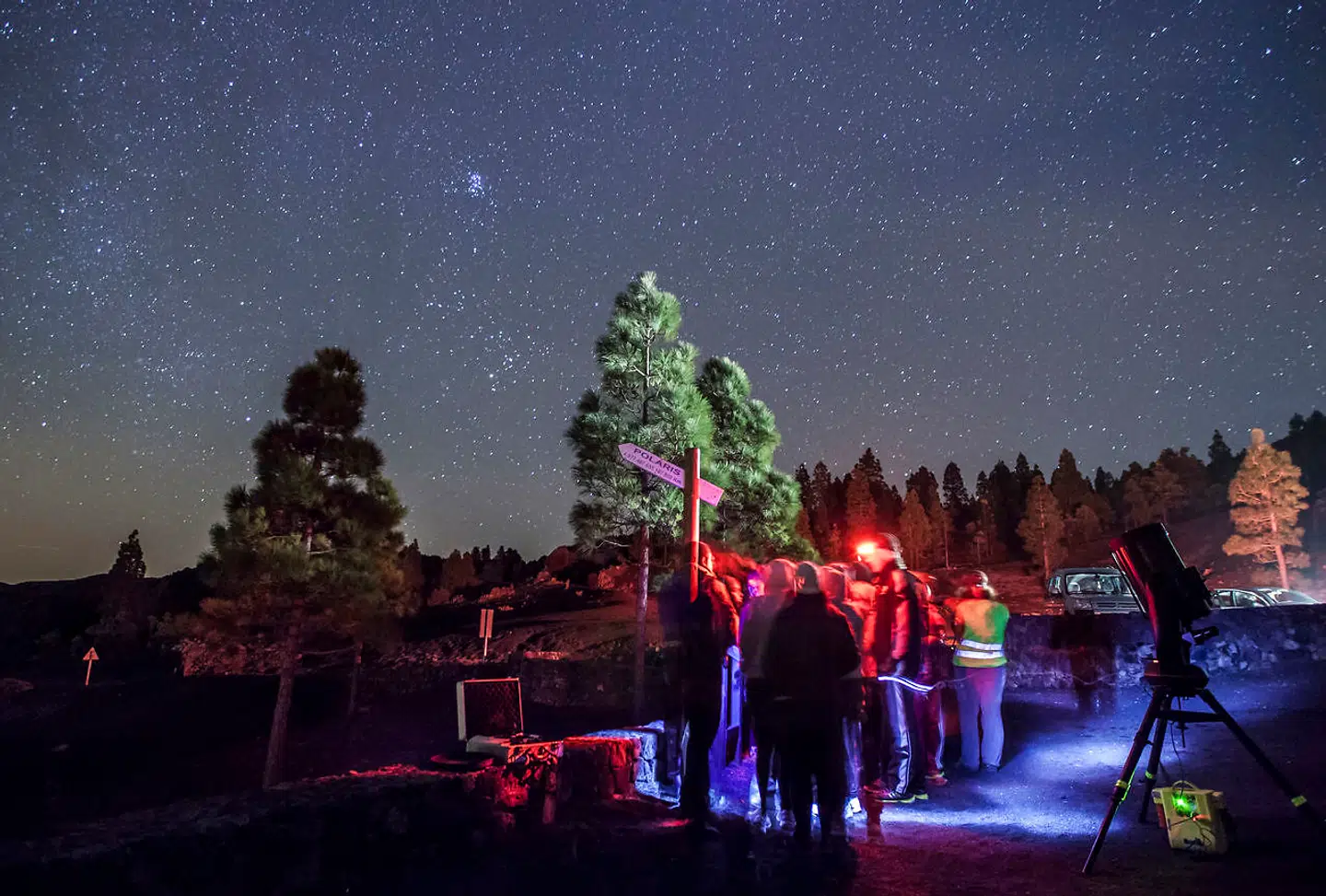 Et teleskop er stillet op, og deltagerne i en stjernekigning-udflugt flokkes om at få et kig.