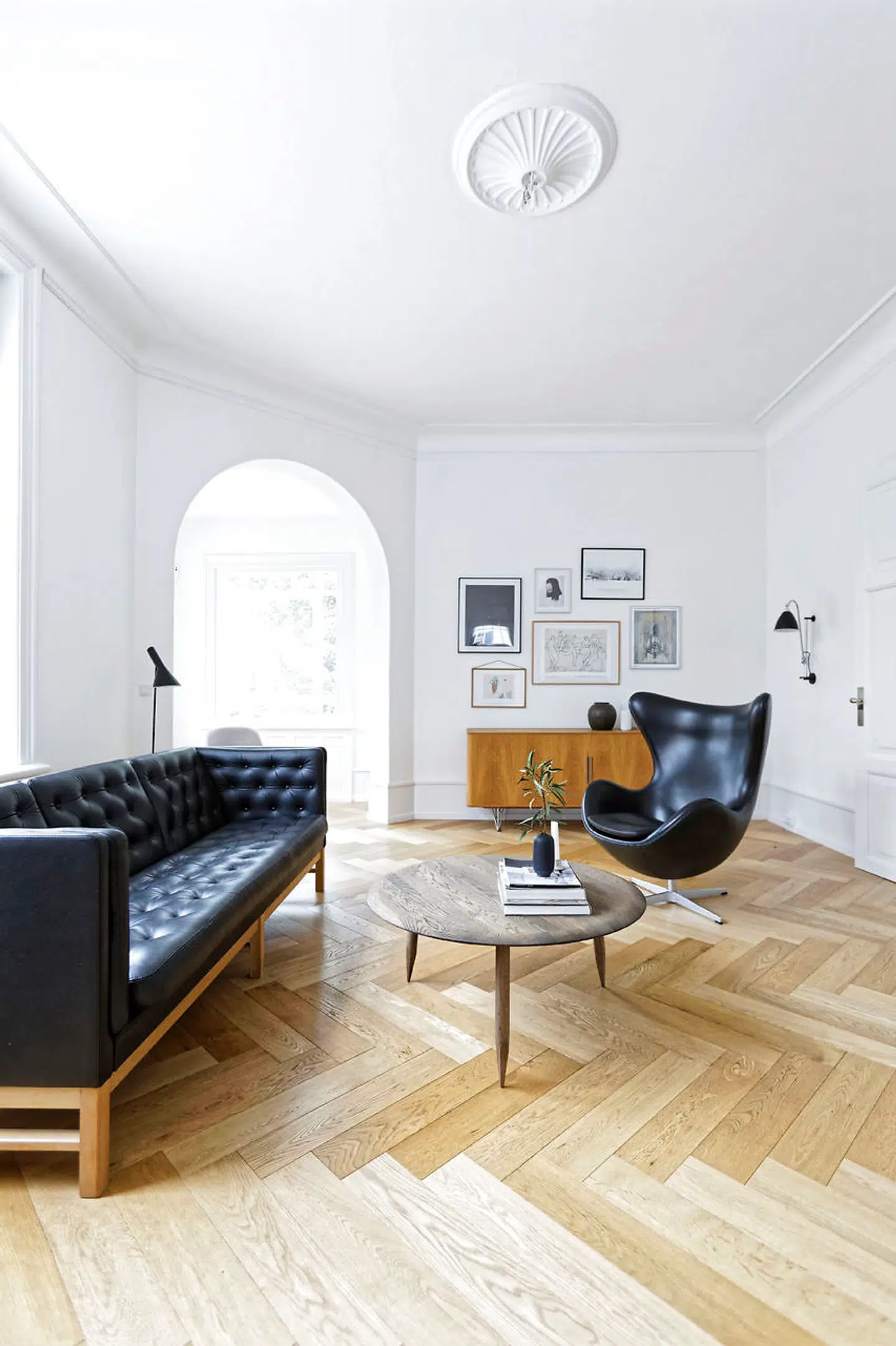 Den klassiske Erik Jørgensen EJ 315-sofa med sort læder passer til bordet med blyantsben i røget eg fra &tradition.