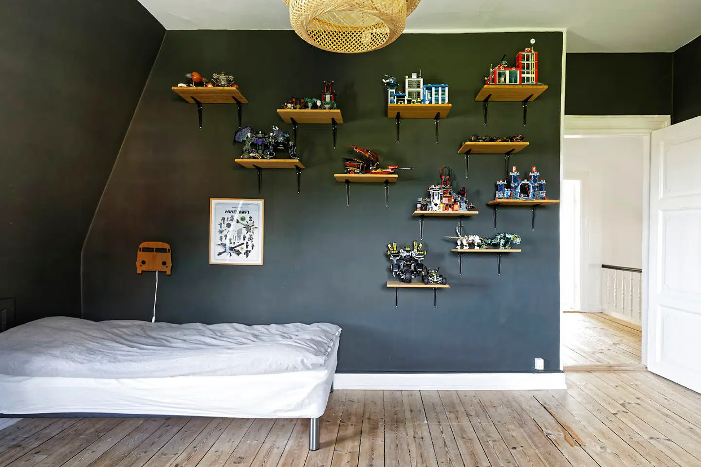 Sønnens værelse på første sal er det eneste med koksgrå vægge. Lego-figurer står på spredte hylder lavet af Ruben Hjelmberg.