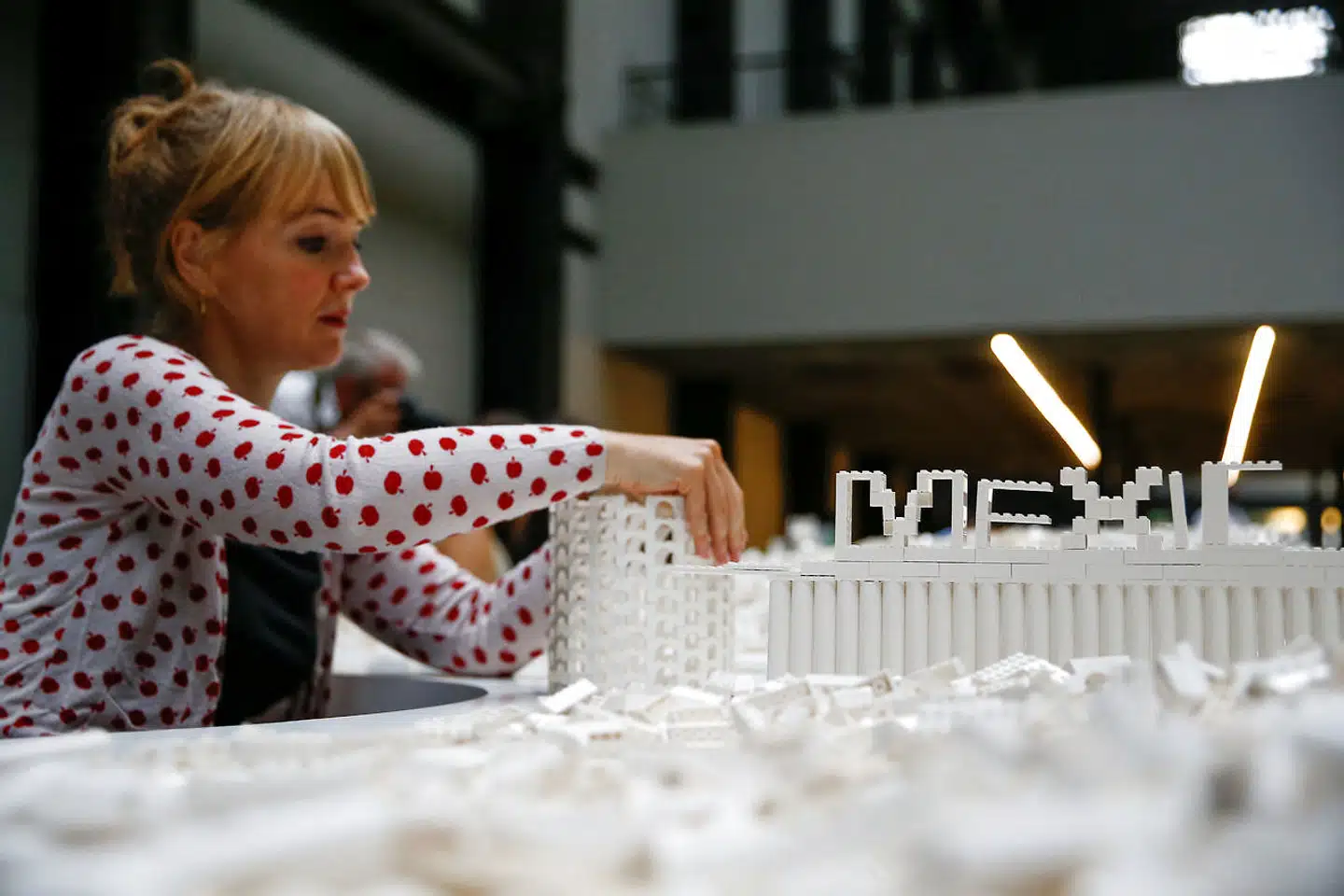 Lego dukker op i mange sammenhænge verden over. Den islandske kunstner Olafur Eliasson udstiller i øjeblikket værket »The cubic structural evolution project 2004« i Tate Modern's turbinehal i London. Her interagerer publikum med kunstværket, som består af et ton hvide legoklodser fordelt på to borde, 26. juli i år. Foto: Henry Nicholls / Reuters / Scanpix