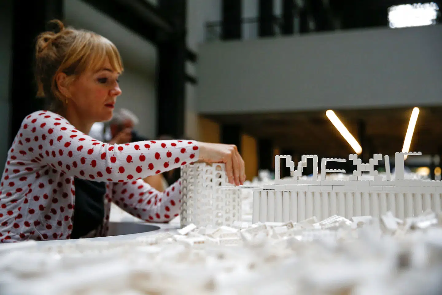 Lego dukker op i mange sammenhænge verden over. Den islandske kunstner Olafur Eliasson udstiller i øjeblikket værket »The cubic structural evolution project 2004« i Tate Modern's turbinehal i London. Her interagerer publikum med kunstværket, som består af et ton hvide legoklodser fordelt på to borde, 26. juli i år. Foto: Henry Nicholls / Reuters / Scanpix