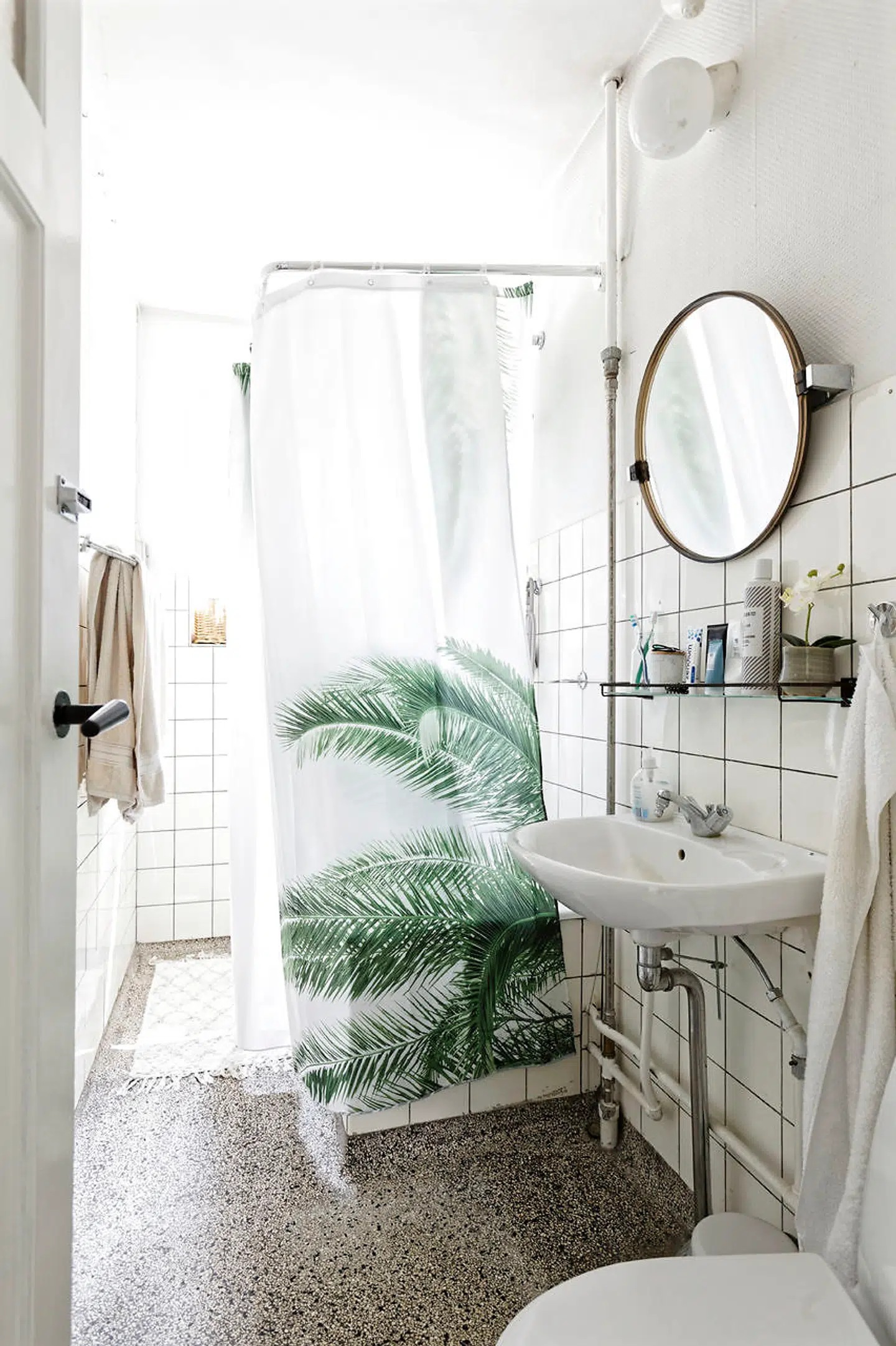 Fliserne fra 1940 sidder stadig i badeværelset, hvor der også er det oprindelige terrazzogulv. Marie Alstrup ønsker sig et nyt badeværelse, når hun får råd. Bruseforhænget er fra Jysk.