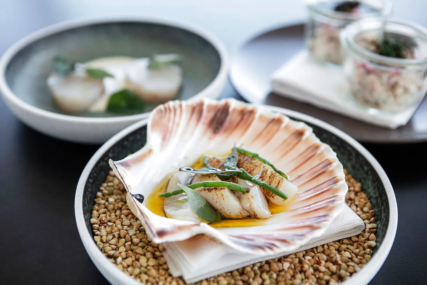 Anden ombæring af snacks: kammusling, tempereret torsk og rejesalat.