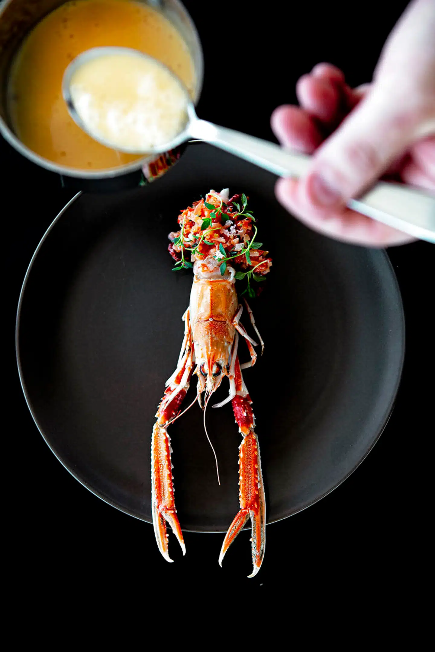 Jomfruhummer bagt med spæk og serveret med rød peber, tomat, timian og sauce basqauise.