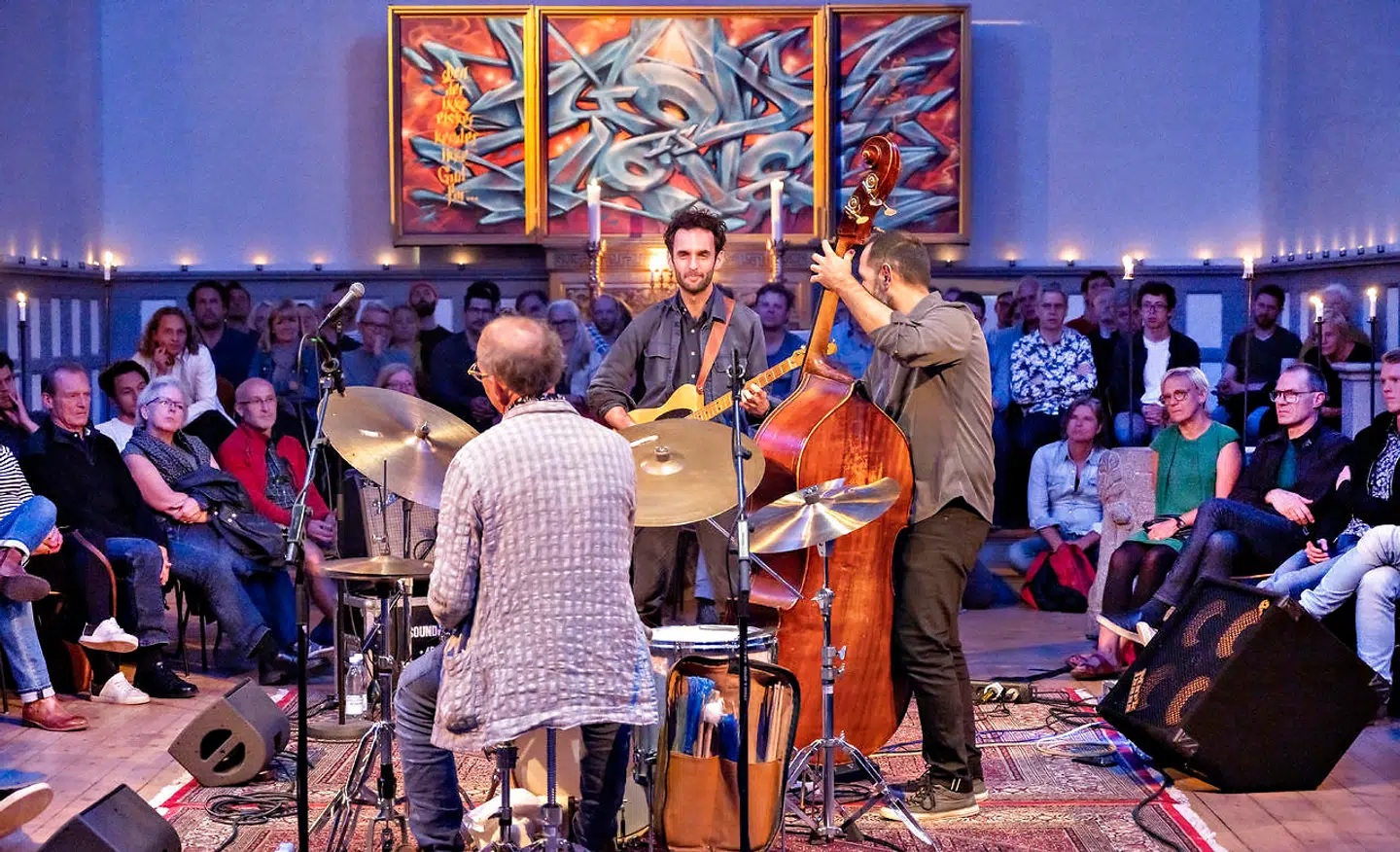 Guitaristen Julian Lage i selskab med bassisten Jorge Roeder og trommeslageren Kenny Wollesen -med ryggen til alter og publikum i Brorsons Kirke.