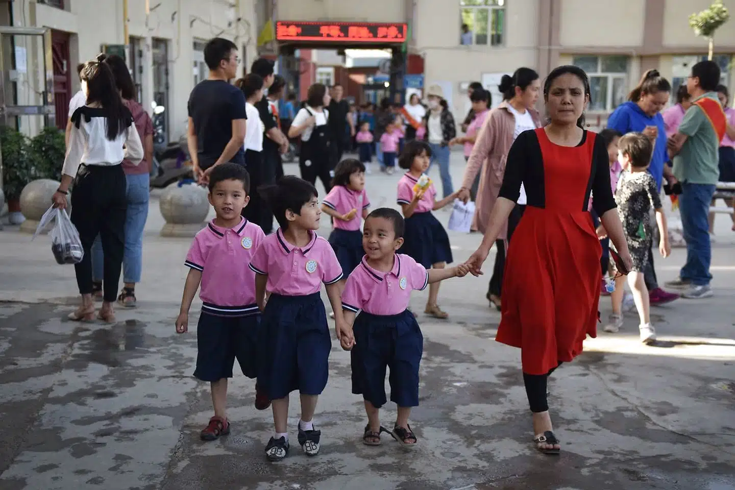 En gruppe skolebørn går rundt i Hotan i Kinas vestlige Xinjiang-regionen. Her på pladsen lå engang en moské, men den er nu blevet revet ned, skriver AFP.