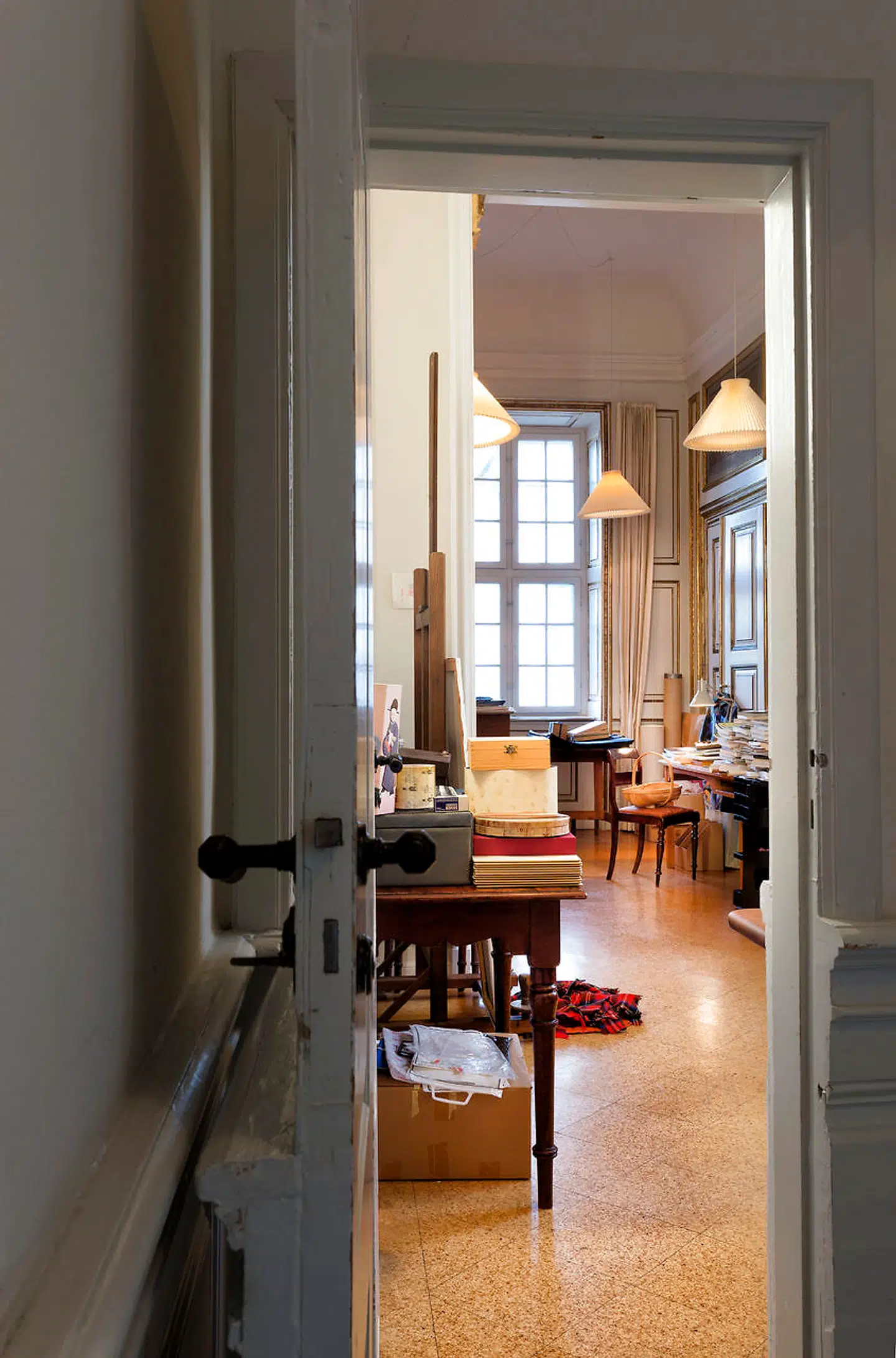 Dronningens atelier: Døren ind til dronning Margrethes atelier er så undseelig, at man aldrig selv ville få den tanke, at der bag den skulle åbne sig en Aladdins hule, dronningens private hobbyrum. Dronningen har indrettet sig meget praktisk med staffeliet til venstre – med den obligatoriske hundekurv under – og arbejdsbordet til højre.