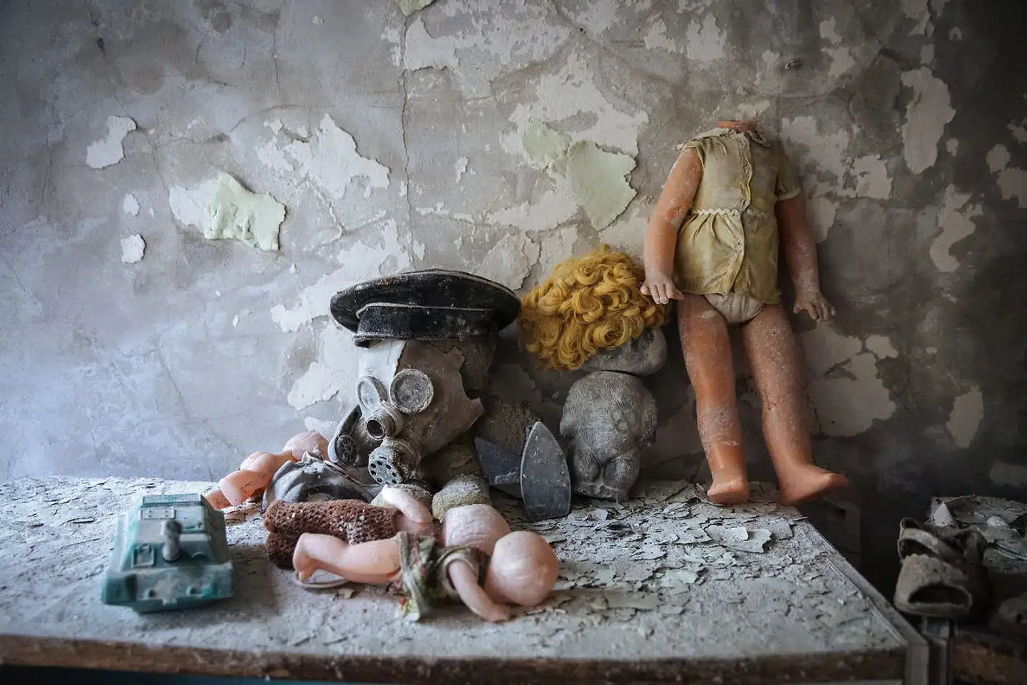 «Mens dyr og planter i et par og tredive år har koloniseret Den Lukkede Zone i det usædvanlige fravær af mennesker, har videnskabsmænd og interesseorganisationer – herunder indædte kernekraftsmodstandere – kæmpet om ulykkens eftermæle,« Her ses en gasmaske og dukker i en børnehave i den forladte by Pripjat.