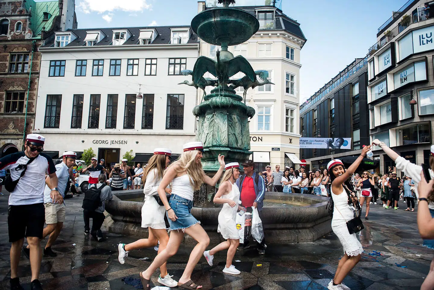 Studenter fejrer eksamen ved Storkespringvandet i København.