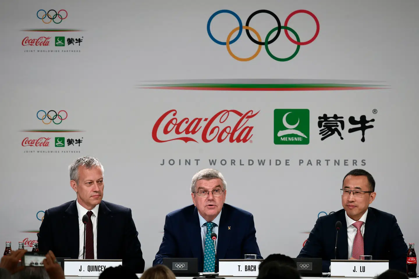 International Olympic Comittee holdt pressemøde mandag 24. juni. Fra venstre: Coca-Colas administerende direktør James Quincey, Thomas Bach fra OL-komiteen og og Mengniu Dairys administrerende direktør Jeffrey Minfang.