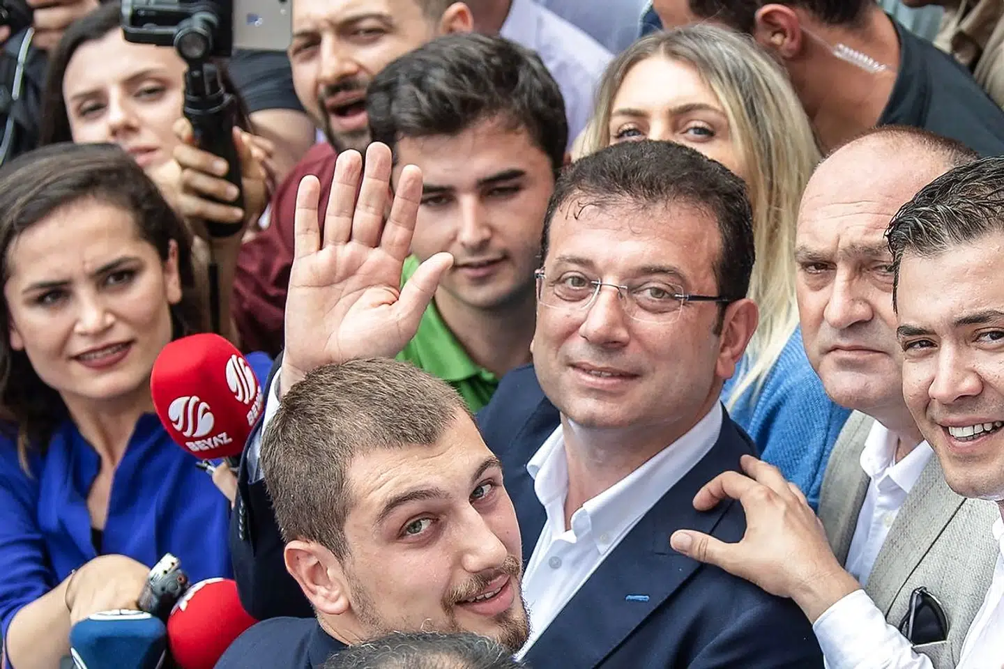 Istanbul mayoral candidate of the main opposition Republican People's Party (CHP) Ekrem Imamoglu waves as he leaves the polling station with his Dilek Imamoglu (behind) and their son Semih ?mamoglu (foreground), on June 23, 2019 in Istanbul. - Istanbul went back to the polls on June 23, 2019 in a re-run of the mayoral election that has become a test of Turkish democracy as well as Turkish President's continued popularity at a time of economic trouble. (Photo by Bulent Kilic / AFP)