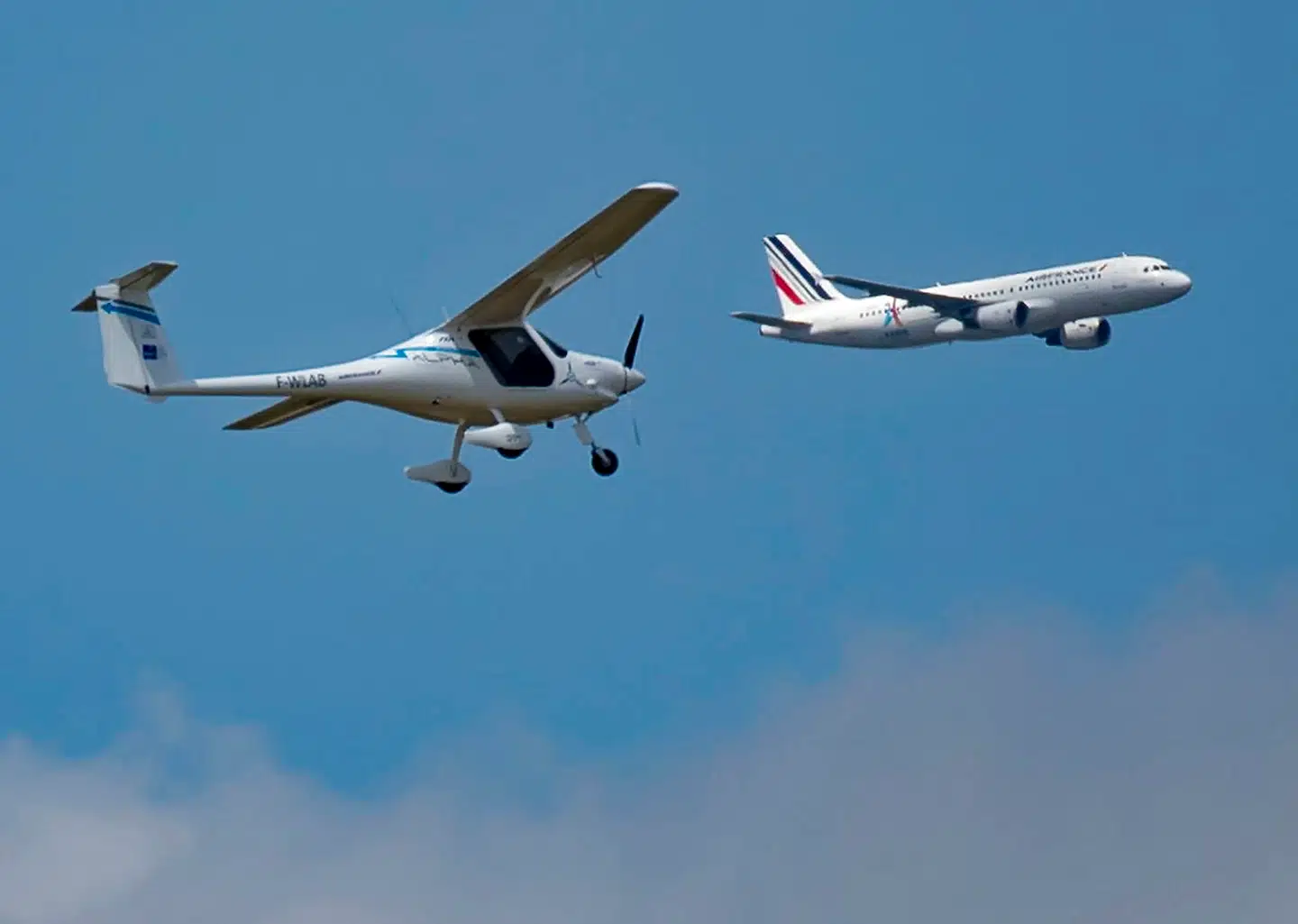 Et mindre elfly, Pipistrel 167 Alpha Electro, demonstreres under Paris Airshow, mens konventionelle passagerfly letter i baggrunden.