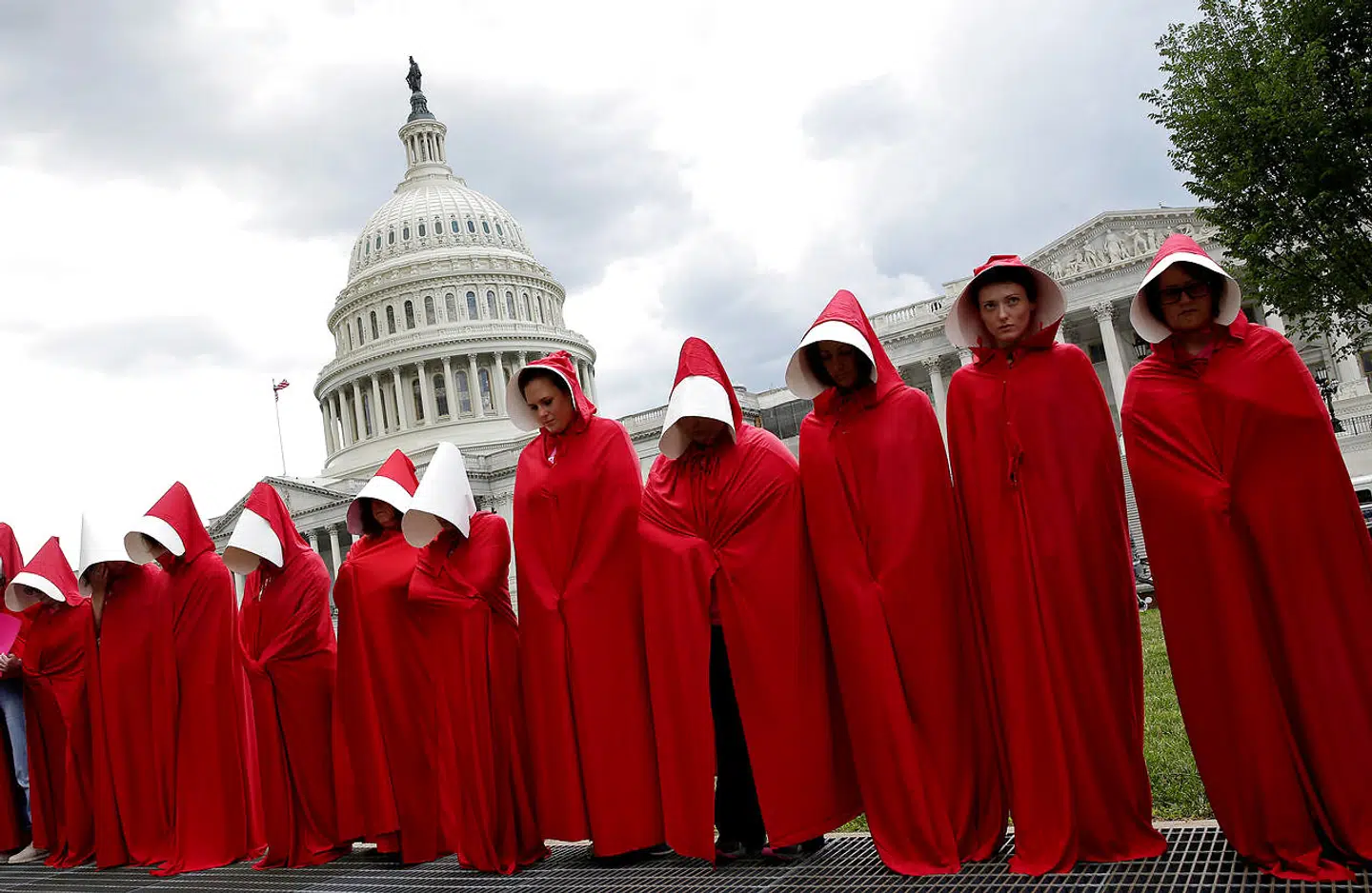 Kvinder, der har klædt sig i kostumer fra TV-serien »The Handmaid's Tale« demonstrerer i 2017 uden for Capitol Hill i forbindelse med republikankse planer om at beskære støtten til svangerskabsforebyggende initiativer.