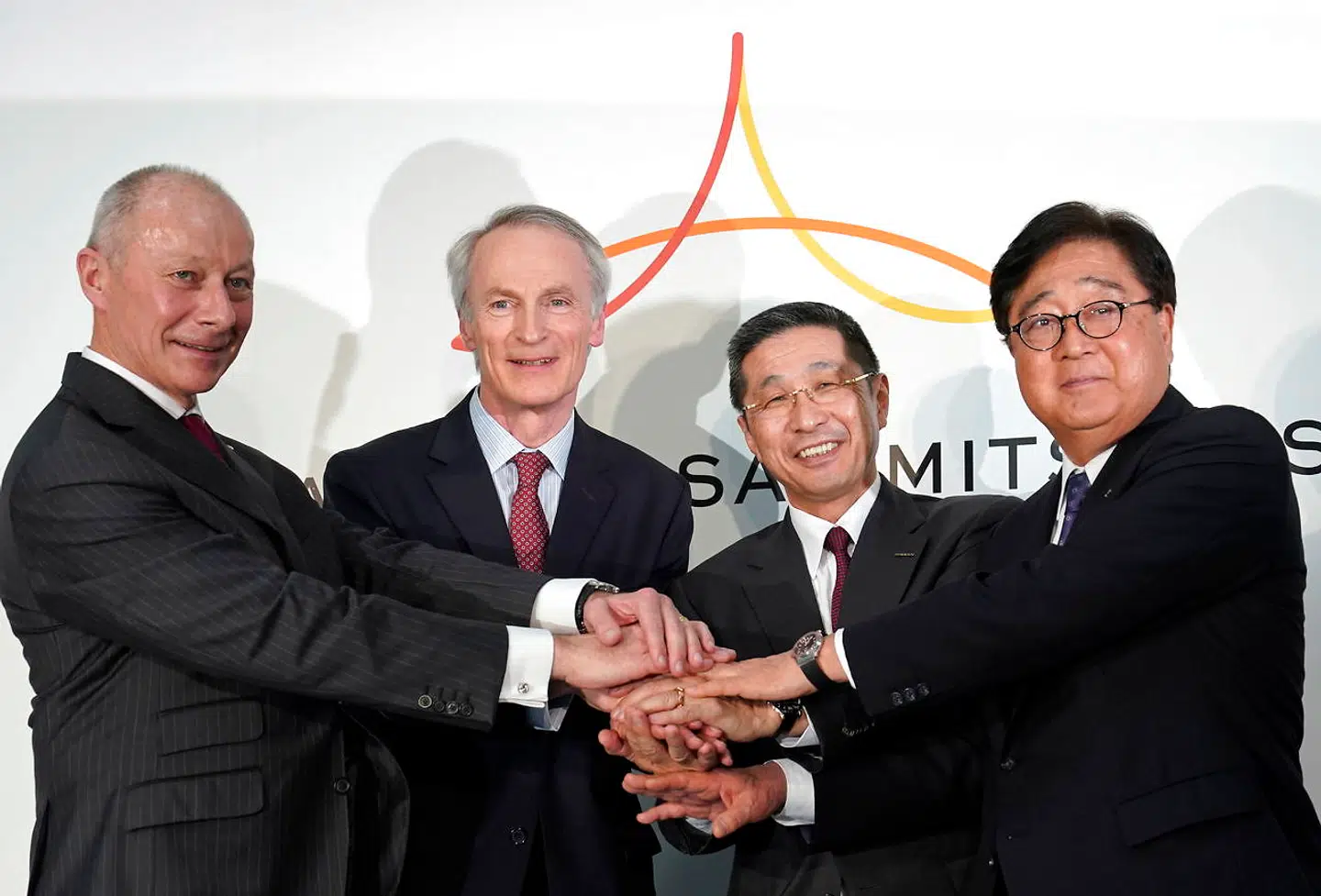 Topcheferne fra Renault-Nissan-Mitsubishi-alliancen slår hånd på en symbolsk musketéred ved en fælles pressekonference i Nissans hovedsæde i Japan i marts 2019. Carlos Ghosns afgang har blotlagt interne spændinger, som endnu ikke er klart bilagt, og Renaults forhandlinger om en fusion med Fiat har skabt ny uro. Fra venstre er det Thierry Bolloré (CEO, Renault), Jean-Dominique Senard (formand, Renault), Hiroto Saikawa (CEO, Nissan) og Osamu Masuko (CEO og formand, Mitsubishi Motors).