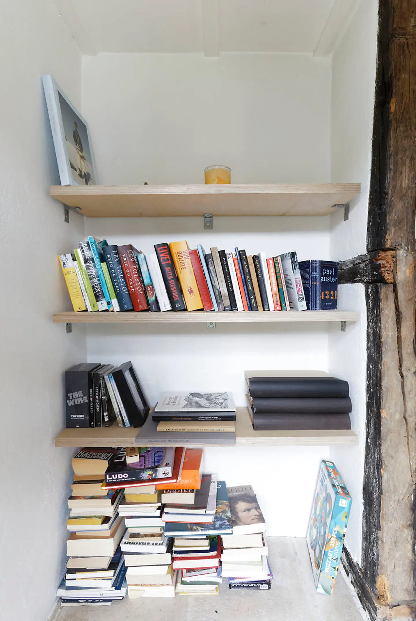 En naturlig niche mellem køkken og stue har givet plads til hylder af birketræsfiner til kogebøger og andre bøger.