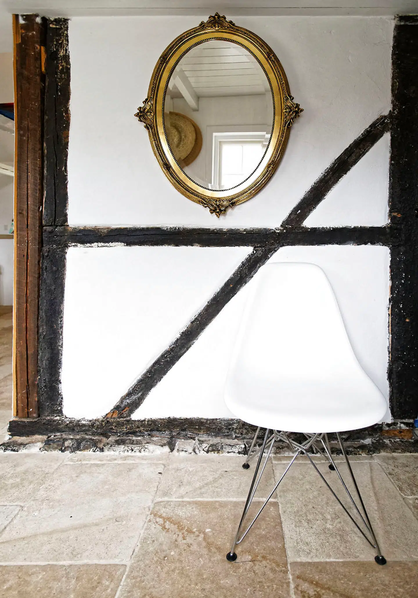 En del af husets oprindelige ydermur ses i vindfanget, som blev bygget, da hus og anneks smeltede sammen for ti år siden. Det antikke spejl er arvet.