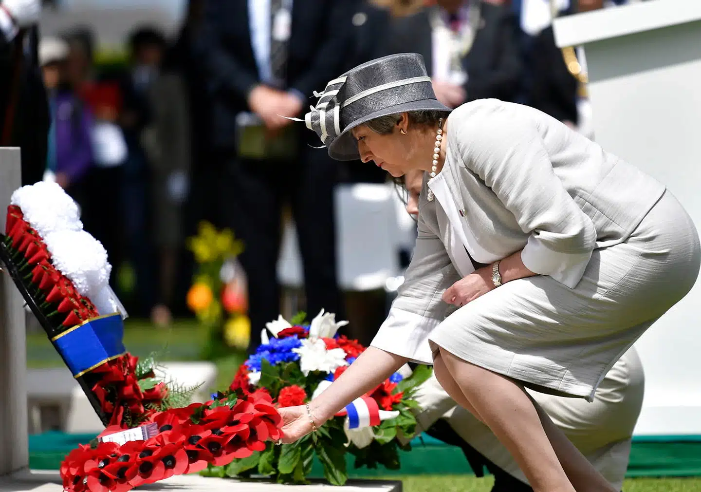 Theresa May har ikke ført kampange i Peterborough, fordi hun blev betragtet som for belastet et navn til at hjælpe partiet – i stedet har hun passet sit job. Her er hun torsdag ved en kransenedlæggelse for faldne britiske soldater ved D-dag.