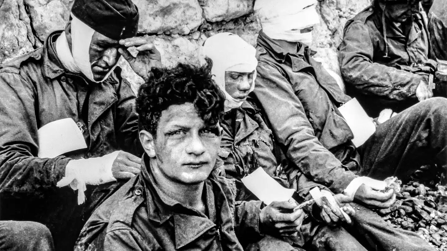 Sårede soldater fra 1. Infanteridivision, 3. baltaljon efter angrebet ved Omaha Beach. Illustration fra »Den røde brænding«