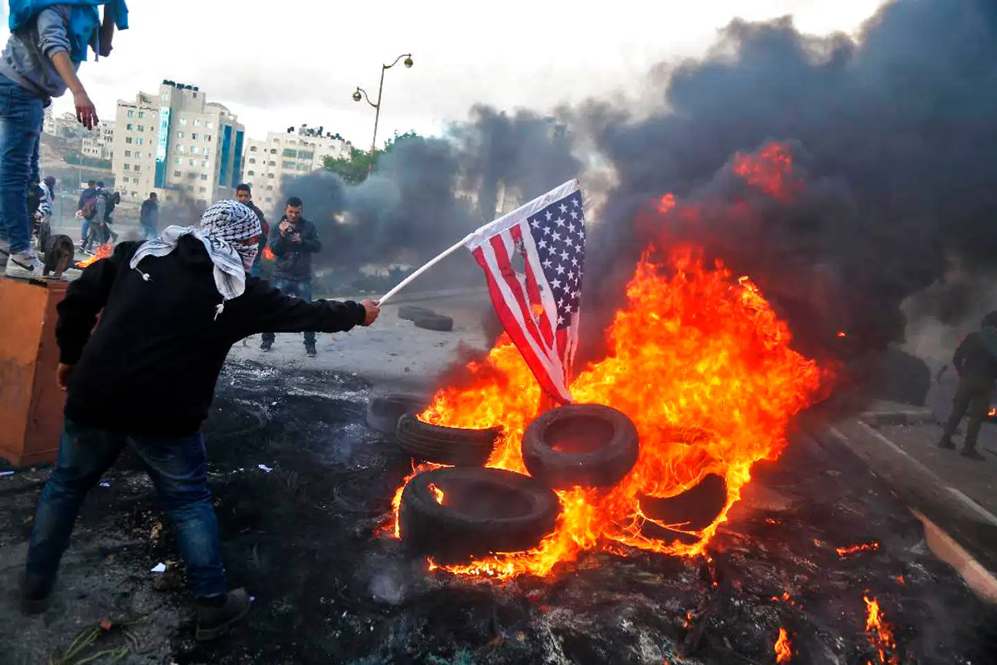 En palæstinensisk demonstrant på Vestbreden brænder et amerikansk flag under sammenstød med israelske soldater som en protest mod Donald Trumps beslutning om at anerkende Jerusalem som Israels hovedstad.