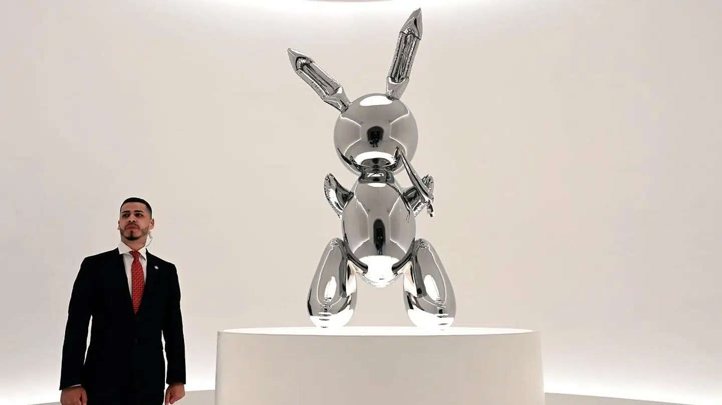 En sikkerhedsvagt står ved siden af Jeff Koons' »Rabbit« i Christie's lokaler i New York. Foto: Timothy A. Clary/Ritzau Scanpix