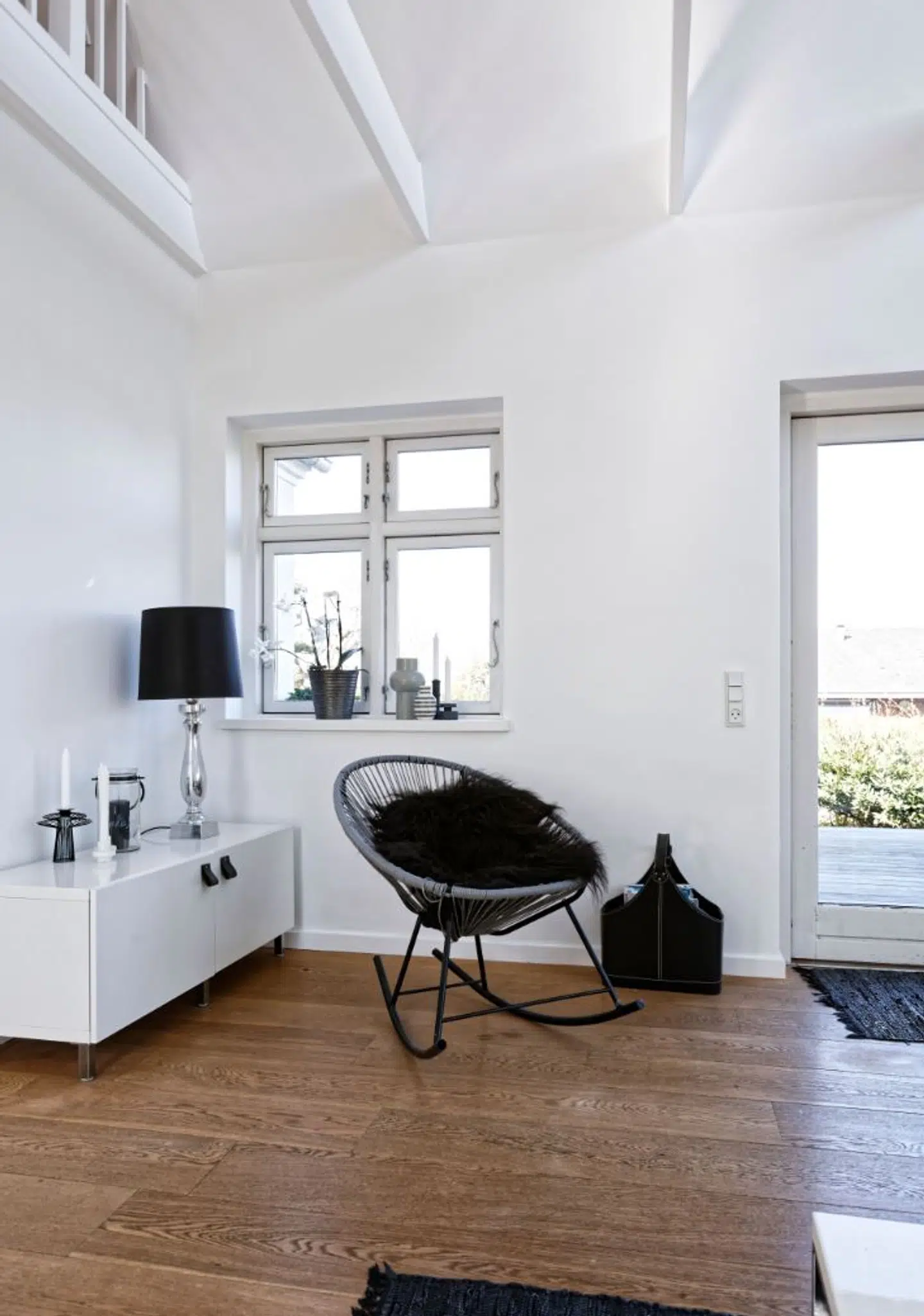 Acapulco-gyngestolen står ved døren med direkte adgang til den store træterrasse. Ikea-skænken er forsynet med læderstropper som greb.