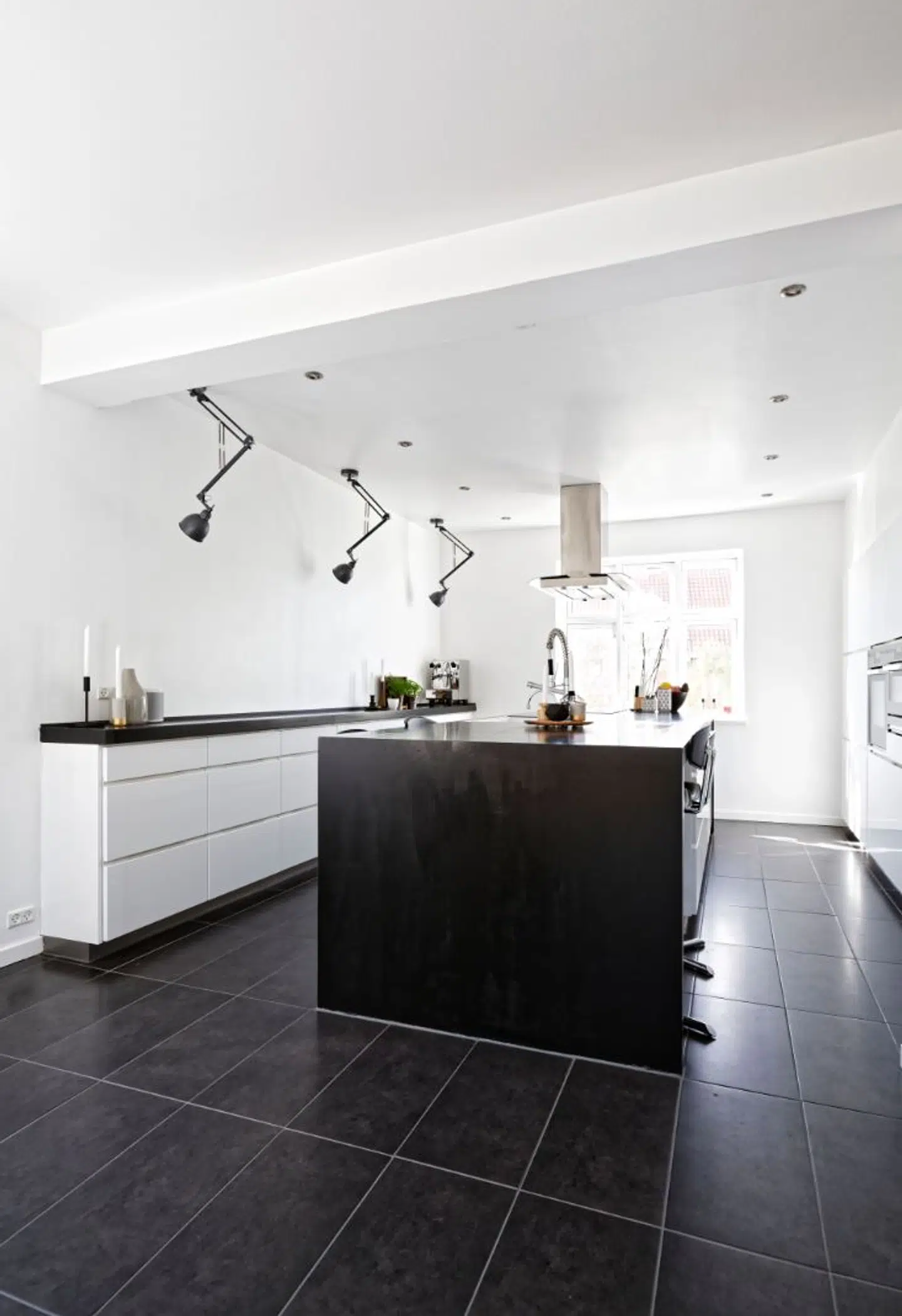 Kvik-køkkenet har lys under bordpladen til krydderiskufferne og opvaskemaskinen. Arkitektlamper monteret i loftet skjuler udtagene og giver indirekte lys.