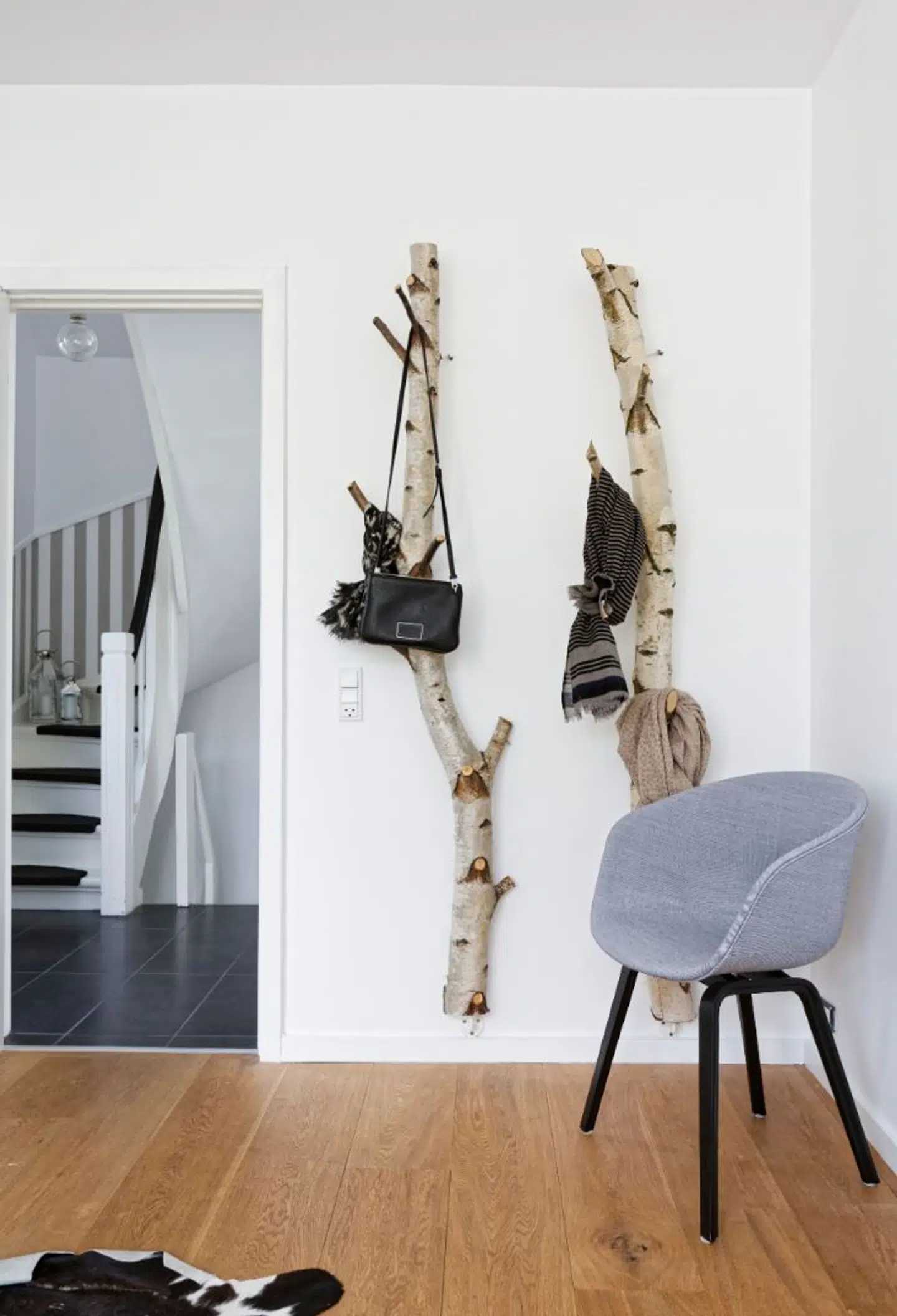 To birkestammer er boret ind i væggen. De fungerer som knagerækker til tasker, tørklæder m.m.