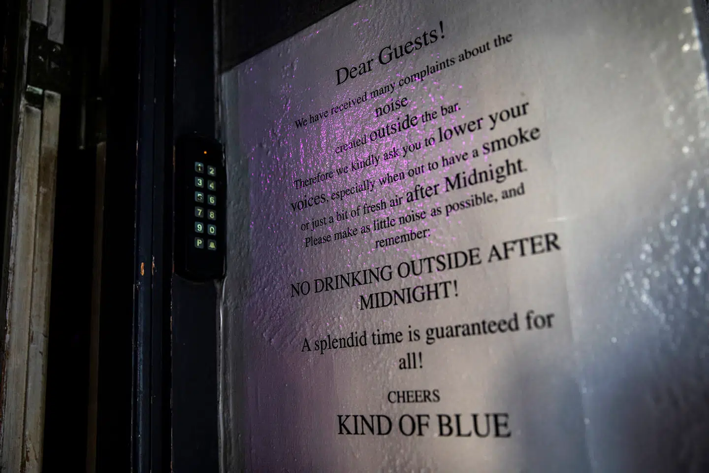 Ved døren ud til Ravnsborggade hænger en opfordring til gæsterne om at dæmpe sig, når de er udenfor.