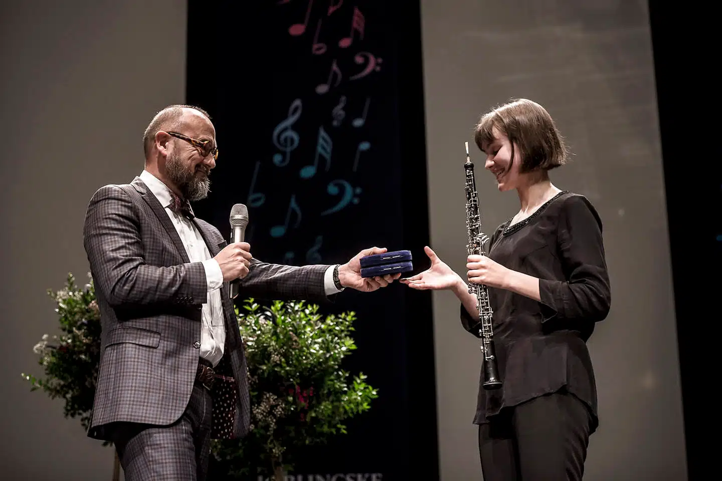 Michael Bojesen overrækker ved finalekoncerten i Tivoli i 2016 guldmedalje til 15-årige Clara May Teahan for hendes indsats på obo.