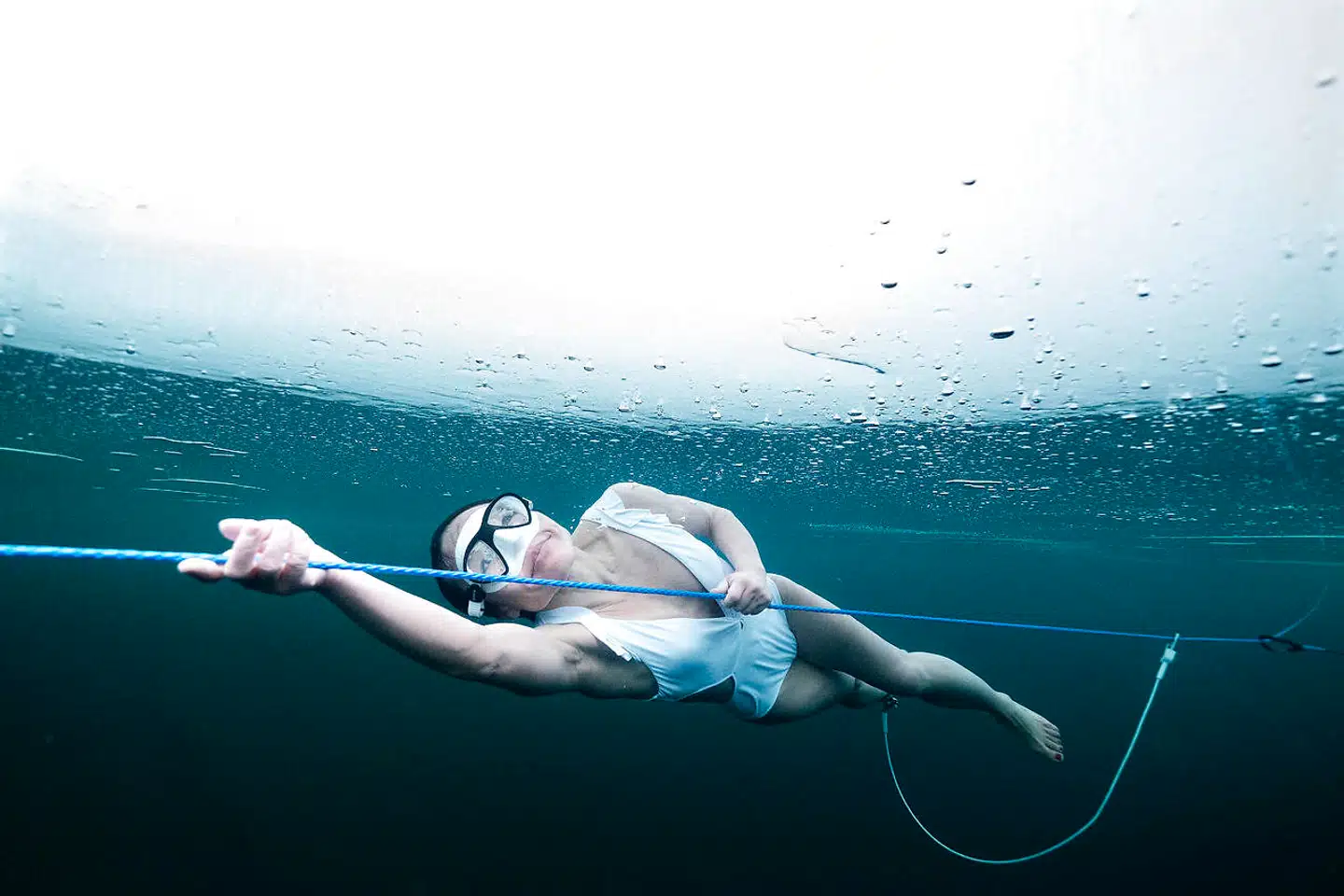 Wendy Lui svømmer 20 meter under is fra ishul til ishul. I bikini. Wendy fik i 2017 en meniskenskade og genoptrænede i vand og ved hjælp af isterapi.»Så nu fortæller min hjerne mig, at det er godt for mig. At kulden er god for mig. Den har en helende magi. Mit første egentlige dyk under is var i februar i år, og siden har jeg været afhængig af det. Jeg er tiltrukket af kulden, af friheden under vandet, følelsen af at være i en anden verden og af skønheden under isen. Først er det altid et chok at komme i vandet. Det er iskoldt, hele min krop fryser, tiden fryser, men når jeg begynder at bevæge mig, så kan jeg slappe af. Kulden aktiverer adrenalin. Det føles, som om hele min krop bliver fornyet. Den gør mig glad.«Under isen er der ingen referencepunkter, og man mister let alt fornemmelse af retning. Wendy er spændt fast til en line, der går fra ishul til ishul, og har sikkerhedsdykkere i hvert ishul og en dykker, der følger hende under isen. Dykkerne skal vide, præcist hvor de er, og kende egne grænser. Og så dykker man aldrig alene.
