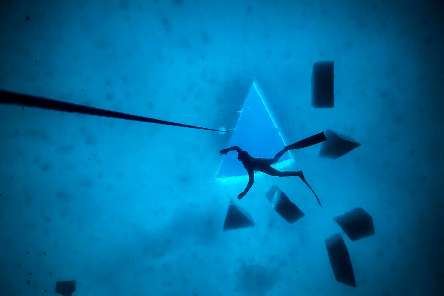 For at få adgang til isuniverset skærer fridykkerne huller i den 30-40 centimeter tykke is. Hullerne bliver skåret ud i trekanter. Det er mest praktisk, mindst is skal flyttes. Isblokkene, som ligger under isen, er fra det trekantede hul – og rebet er til at dykke langs som sikkerhed for dem, der ønsker at dykke dybt.