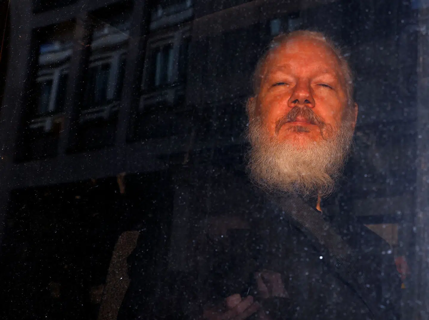 Julian Assange efter sin anholdelse uden for Ecuadors ambassade og på vej væk i et salatfad.