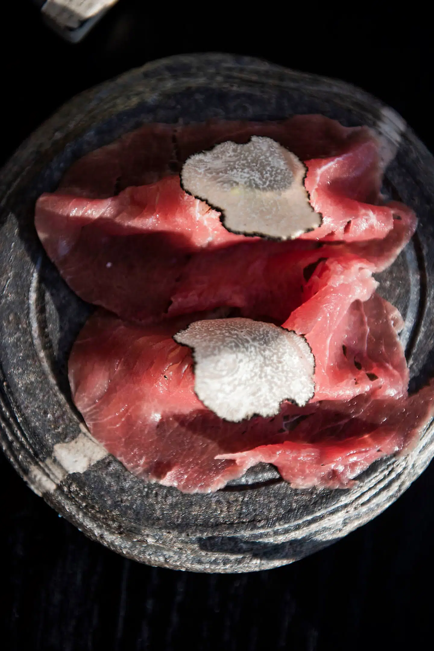 Oksekødsnigirien består af to ultratynde og supermøre skiver af ildrød oksefilet, letmarineret i teriyaki-sauce og serveret med både trøffelcreme og skiver af frisk trøffel.