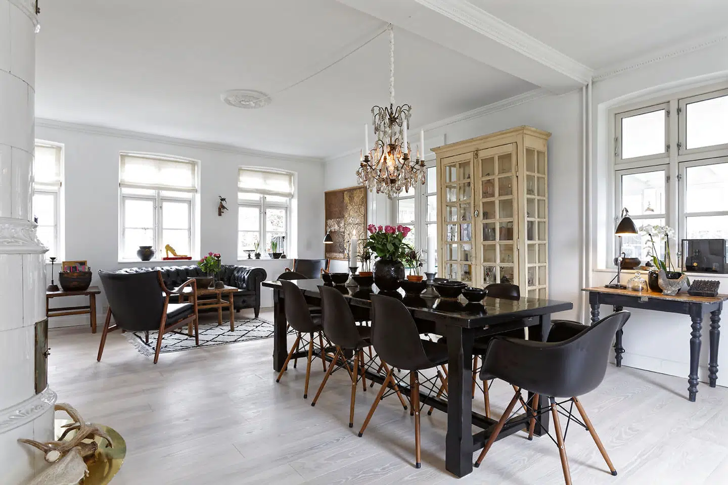 Langbordet med Charles Eames-stole omkring er højglanslakeret i sort. Keramikken er Jannes eget design, og lysekronen er fra Green Square.