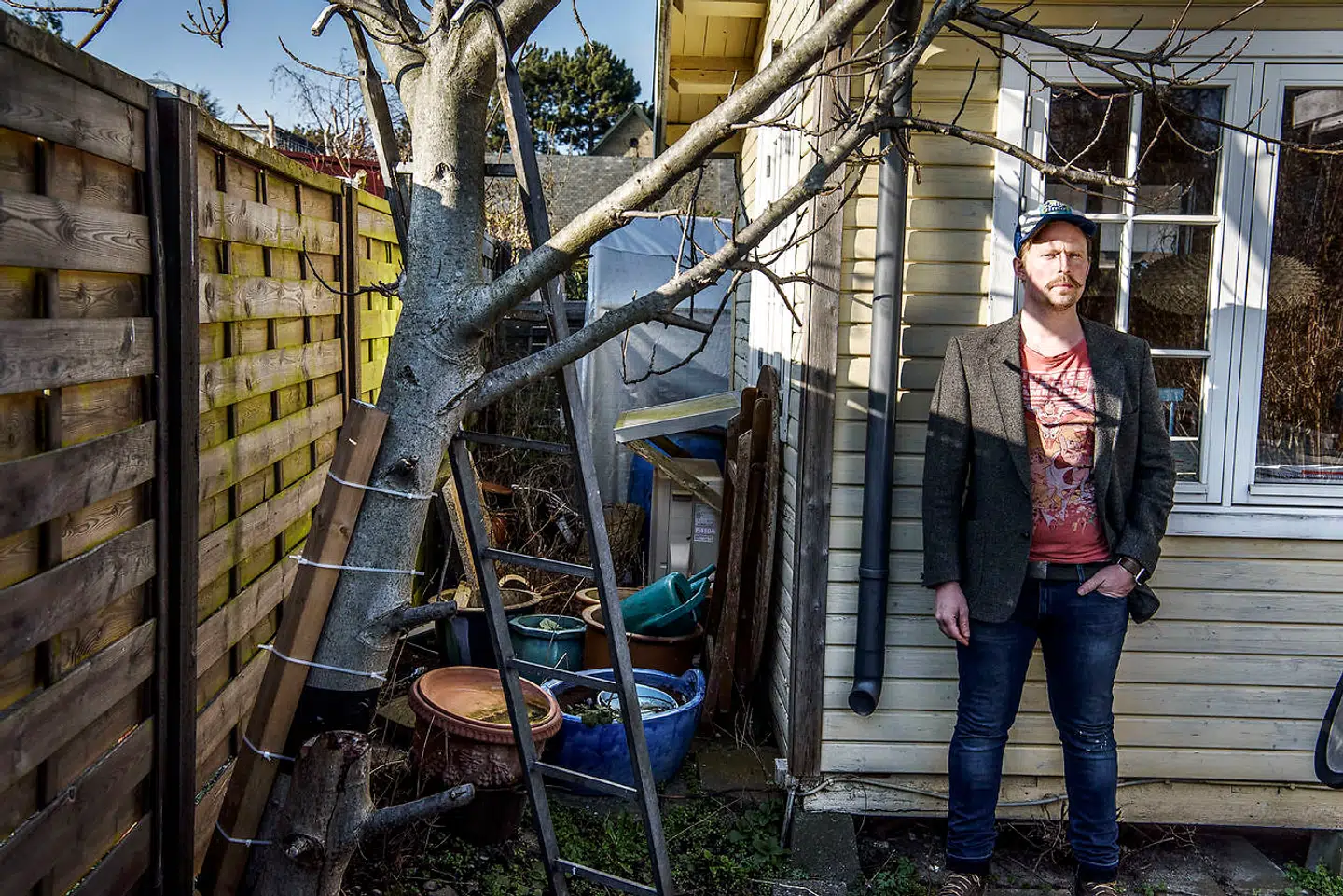 Jesper Bergqvist foran sit kolonihavehus med den tilbageværende af valnøddetræets to stammer, som han forsøger at holde på plads med strips og tape. »At ødelægge levende ting og ødelægge ejendom, som har mere end bare en fysisk eller økonomisk værdi, pisser mig helt vildt af,« siger han, hvis afdøde mor i sin tid plantede træet.