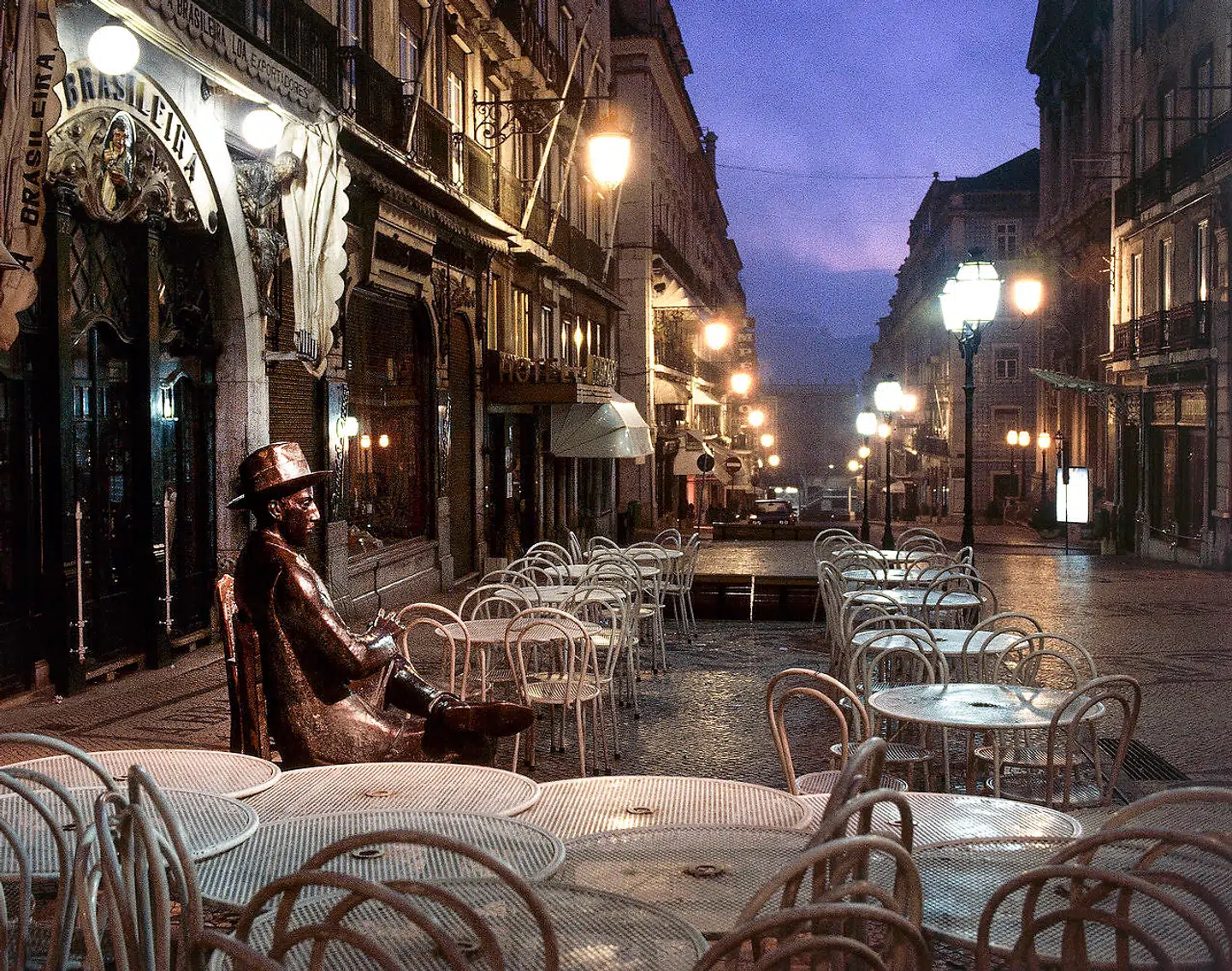 »Meget passende kan gæsten, der slår sig ned ved bordet på cafeterrassen spørge sig selv, hvem det i grunden er, hun eller han sætter sig ved siden af. For bag navnet Pessoa gemmer sig en mangfoldighed af navne og forskellige identiteter,« skriver Berlingskes anmelder. Rua Garret i Lissabon.