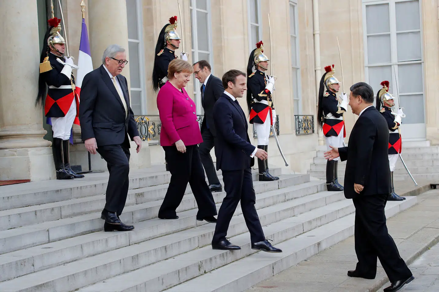 En europæisk power-trio bestående af Frankrigs præsident Emmanuel Macron, den tyske kansler Angela Merkel og kommissionsformand Jean-Claude Juncker byder Kinas præsident Xi Jinping velkommen før tirsdagens møde.