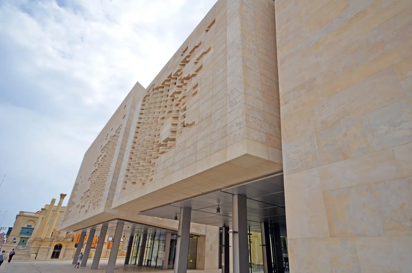 Maltas nye parlamentsbygning er tegnet af arkitekten Renzo Piano. Den er - som så mange andre bygninger på Malta opført i sandsted, der kommer fra store brud på øen, og den moderne bygning gliver ubesværet ind i Malteserriddernes borgmur.