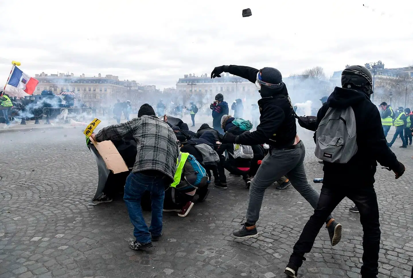 Demonstranter kaster med sten på Place de l'Etoile i det centrale Paris, da De Gule Vests månedlange protester efter en relativt fredelig periode igen førte til gadekampe og hærværk.