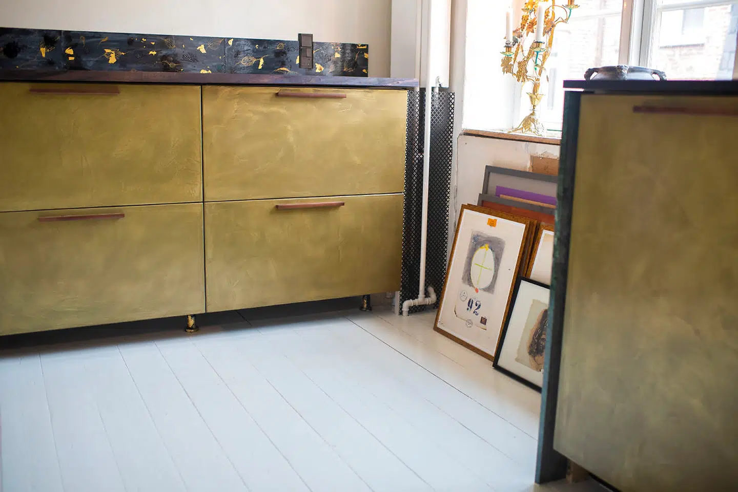 »Fronterne på køkkenskabene er mikrocement blandet med messingstøv. Det er både et maleri og godt håndværk. Messingoverfladen arbejder stadig. Den er ikke færdig med at finde sit udtryk. Den har kun fået voks, så den vil ældes, anløbe og kun blive smukkere,« siger Josephine Bergsøe.